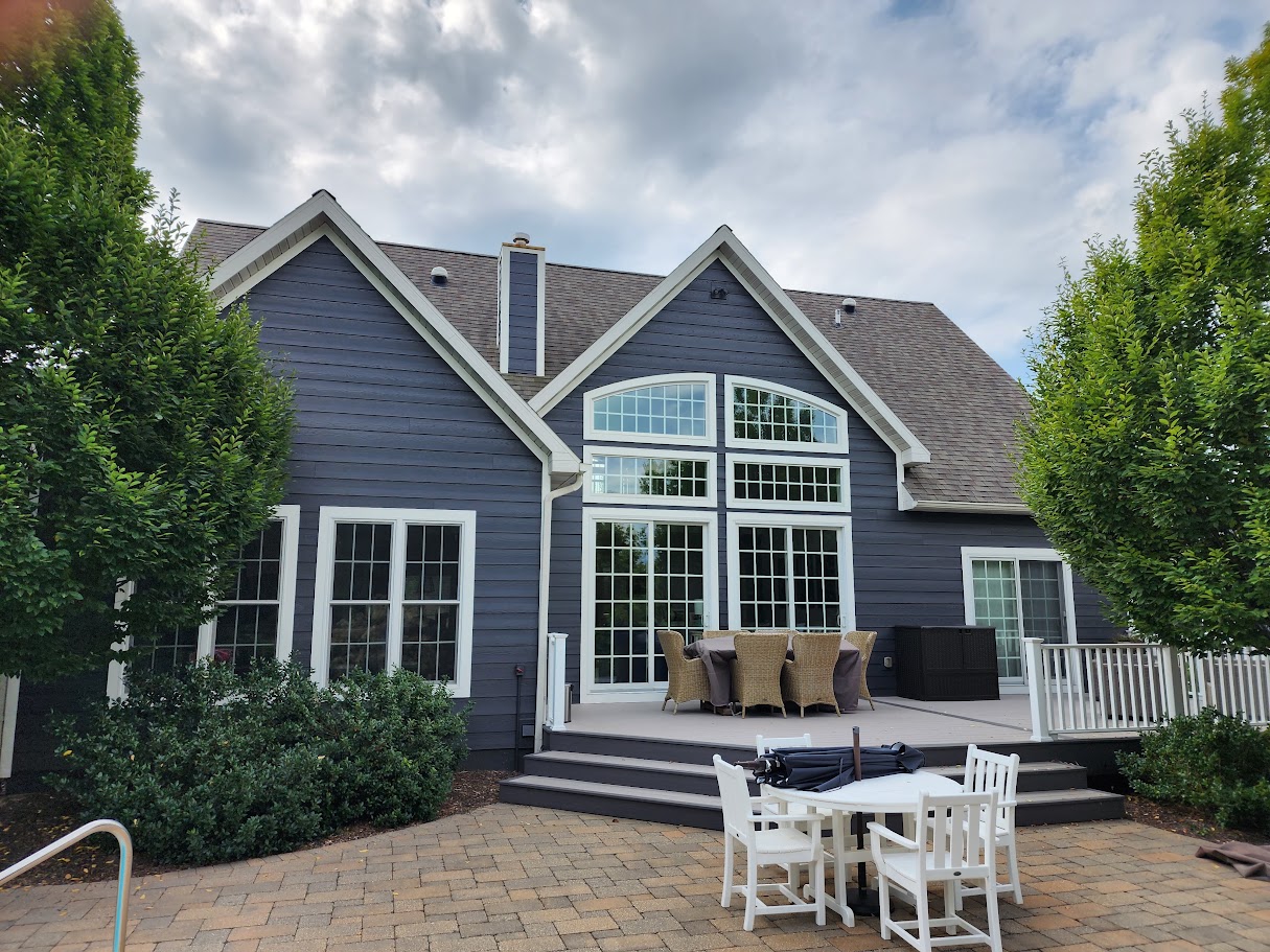 Blue-gray house exterior with white trim and a rear deck