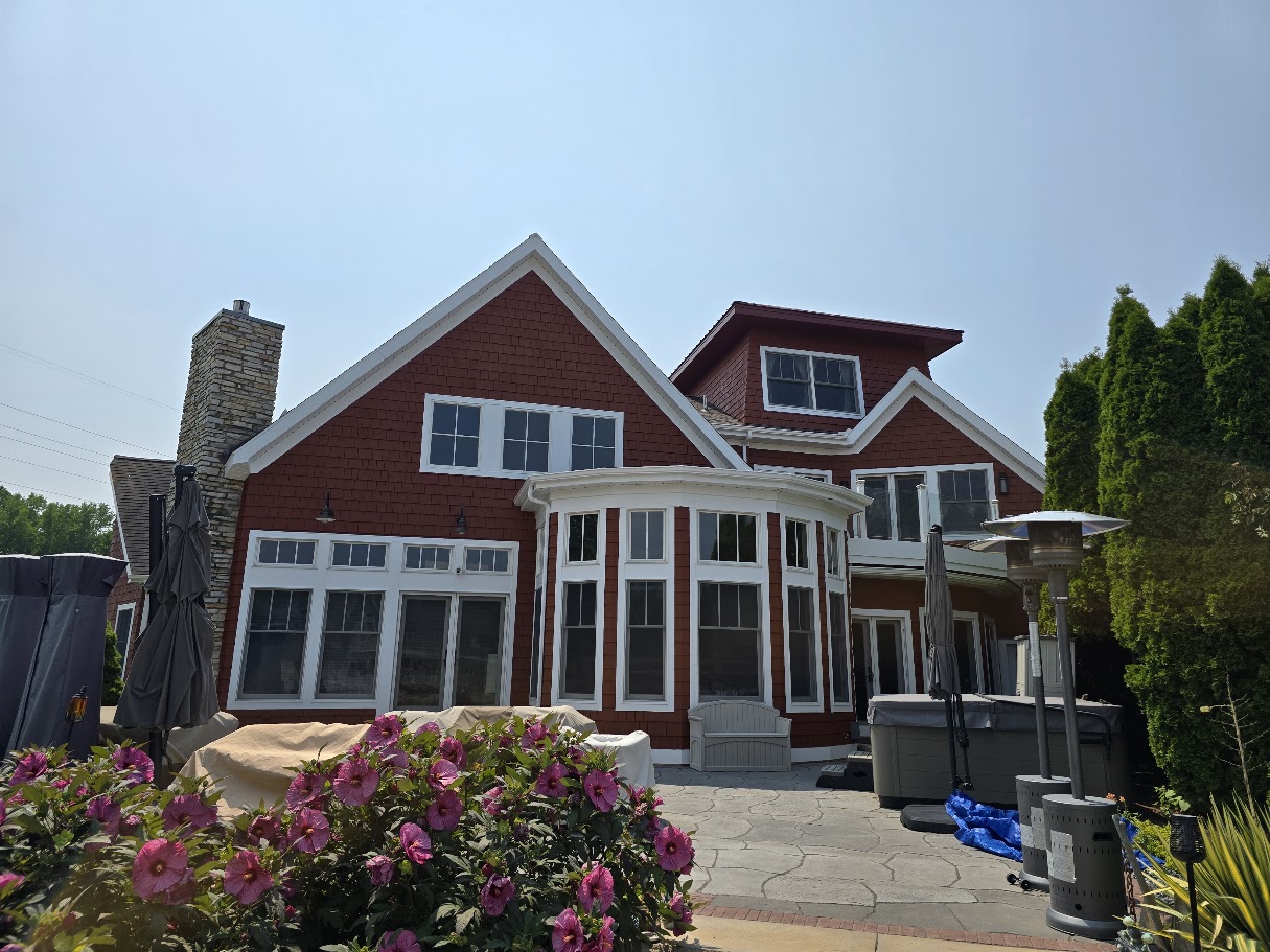 Red shingle house exterior with white trim and a patio