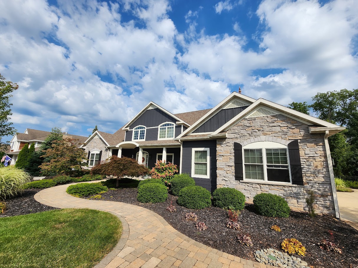 Dark painted siding and stone facade with white trim